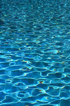 an empty swimming pool with water ripples and blue sky in the backround