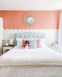 a bedroom with an orange and white color scheme on the wall above the headboard