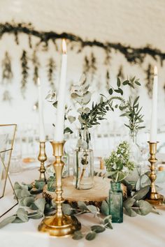 a table with candles and greenery on it