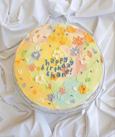 a birthday cake with the words happy birthday written in frosting and flowers on it