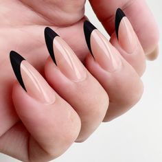 a person with long black nails holding their hand up to show off it's shape