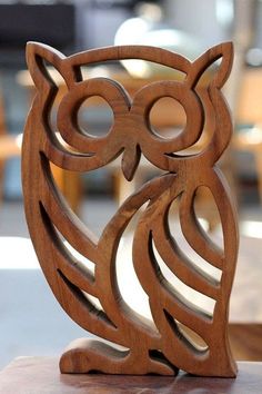 an owl sculpture sitting on top of a wooden table