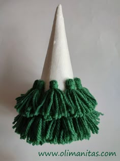 a white cone with green tassels on it