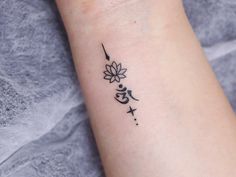 a woman's wrist with a small tattoo design on the left side of her arm