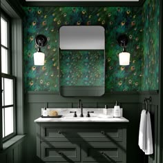 a bathroom with green wallpaper and two sinks in front of a large mirror above the sink