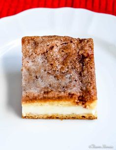 a piece of cake sitting on top of a white plate next to a red cloth