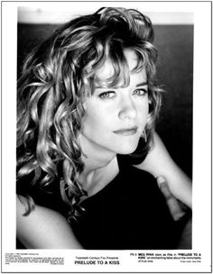 a black and white photo of a woman with long curly hair, wearing a black dress