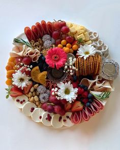 a platter filled with assorted fruits and vegetables on top of a white table