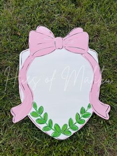 a sign with a pink bow on it that says days of may in green grass