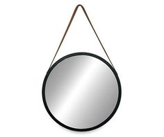 a round mirror hanging on a wall with a wooden handle and leather strap around it