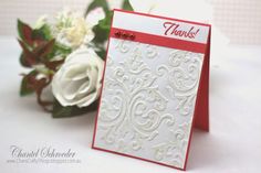 a white and red thank card next to some flowers