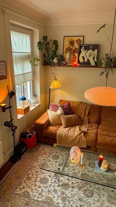 a living room with a couch, coffee table and other items on the floor in front of a window