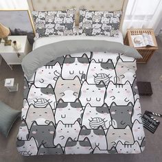 a bed covered in lots of cats on it's cover and pillowcases