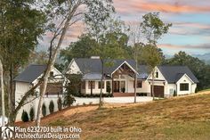 a large white house sitting on top of a lush green hillside