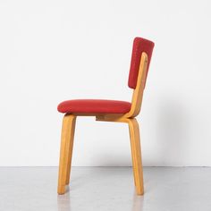 a red chair sitting on top of a white floor