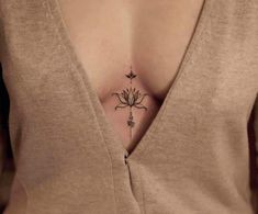 a woman's chest with a small flower tattoo on her left side ribcage