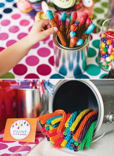 a child's hand reaching into a tin can filled with colorful candy and candies