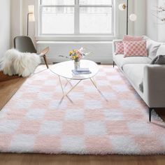 a living room filled with furniture and a pink rug