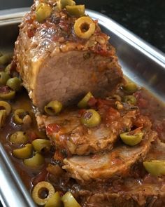 meatloaf with olives and sauce in a metal pan