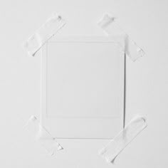 a white square with torn pieces of paper around it on top of a plain surface