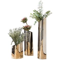 three metal vases with plants in them