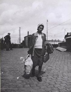 an old black and white photo of a man carrying bags