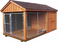 a dog house that is made out of wood and has a metal fence around it