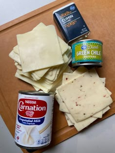 some food is laying out on a cutting board next to a can of cream cheese