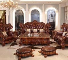 an ornate living room with leather furniture and chandelier