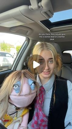 a woman sitting in the back seat of a car next to a stuffed animal doll