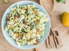 a salad with walnuts and celery in a blue bowl on a wooden table