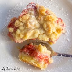 two pieces of strawberry cobbler on a plate with a spoon