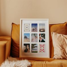 a white framed photo sitting on top of a brown couch next to a pile of pillows