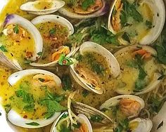 a bowl filled with clams and other food items