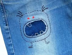 a pair of blue jeans with an embroidered design on the bottom and red stars in the middle