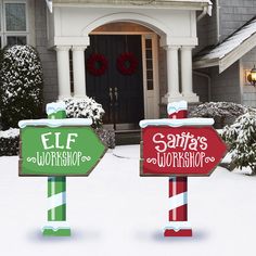 two christmas yard signs in front of a house