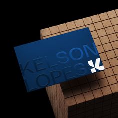 a blue business card sitting on top of a block of wood with the words kellson hopes