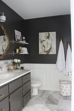 a white and gray bathroom with gold accents