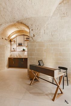 an empty room with a desk and shelves on the wall next to each other in it