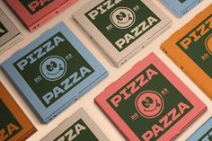 several different colored pizza boxes are arranged in a pattern on the wall behind each other