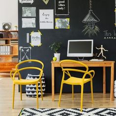 two yellow chairs sitting in front of a desk