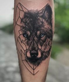 a black and grey wolf tattoo on the right leg with geometric shapes around it's head