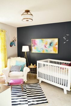 a baby's room with black walls and white furniture