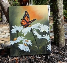 a painting of a monarch butterfly on white daisies in front of a brick walkway