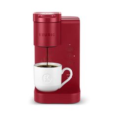 the keurig single serve coffee maker is red and has a white cup on it