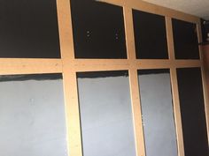 an unfinished room with black and white panels on the wall