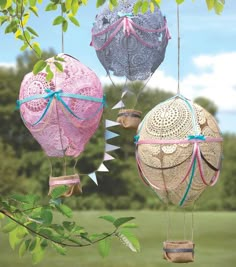 three hot air balloons hanging from a tree