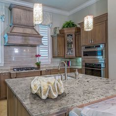 a kitchen with marble counter tops and wooden cabinets