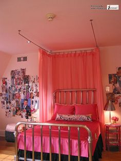 a bedroom with pink walls and pictures on the wall