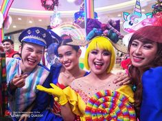 four people dressed up in costumes posing for a photo with each other at a carnival